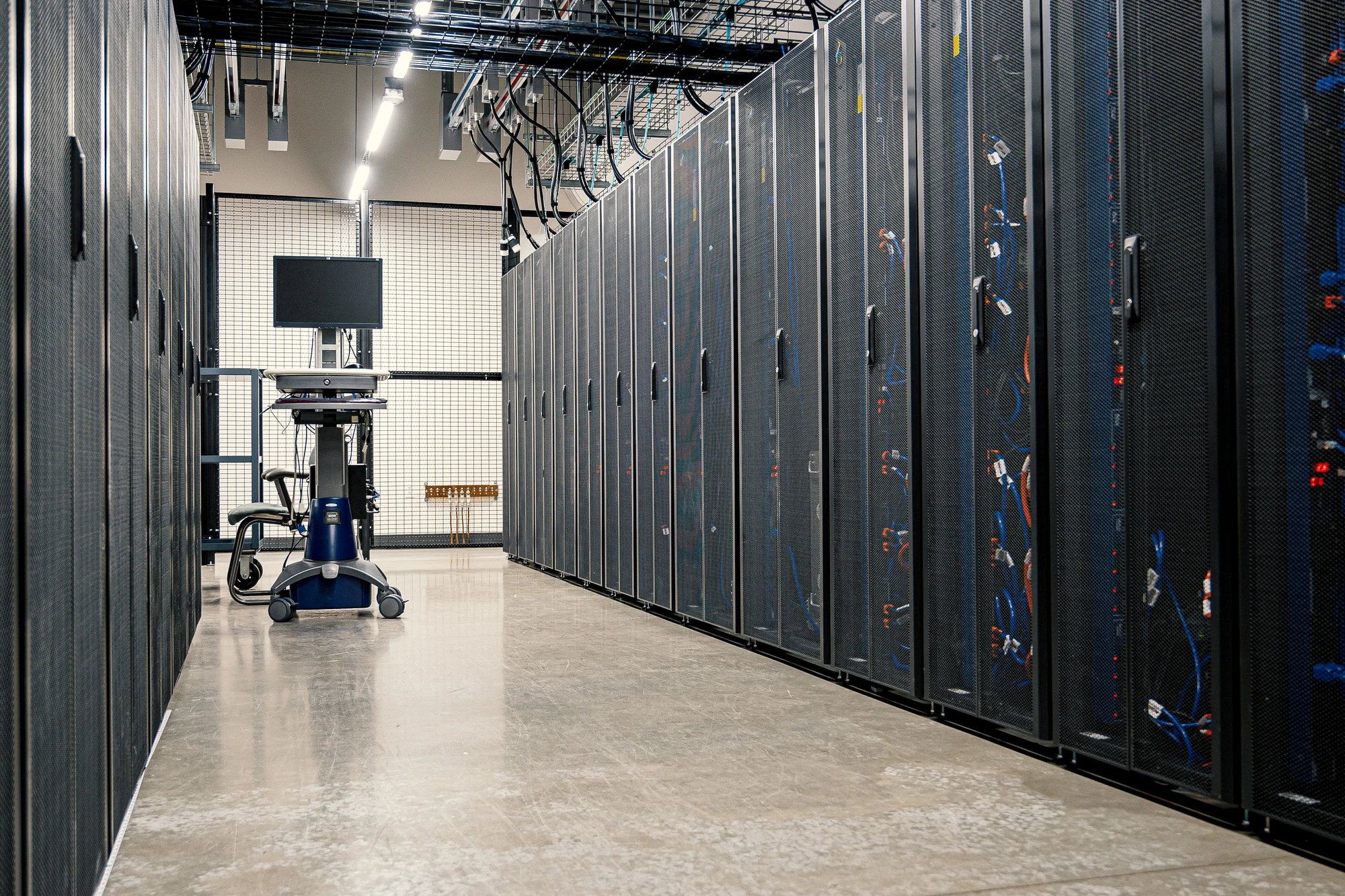 Real data center corridor with server racks representing AI assistant infrastructure
